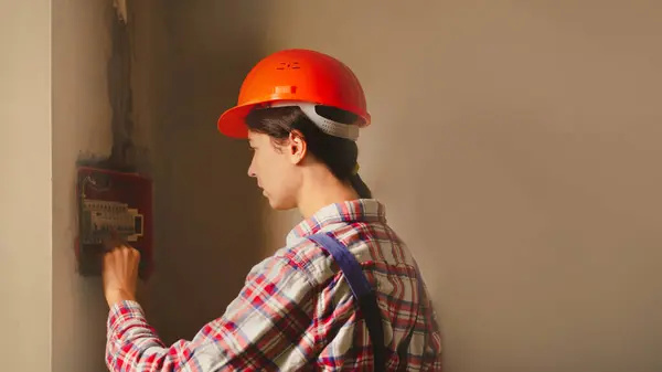 電気技師のビルダー エンジニアはヒューズ箱の自動スイッチを点検します 男性の職業における女性 — ストック写真