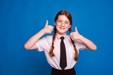 Okul üniformalı, mavi arkaplanlı bir kız.