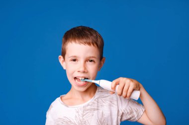 Çocuk diş fırçası ve elektrikli diş fırçası açık mavi stüdyo arka planında izole edilmiş.