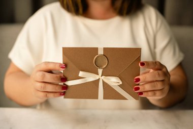 Kadın Elleri Hediye Sertifikası, Yay ve mühür ile bronz zarf