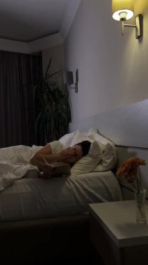 Kadın yatakta kitap okumayı bitiriyor ve akşam uyumaya hazırlanıyor.
