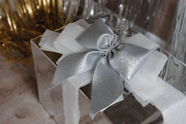 Big silver gift box with big glittering silver bow and ribbons