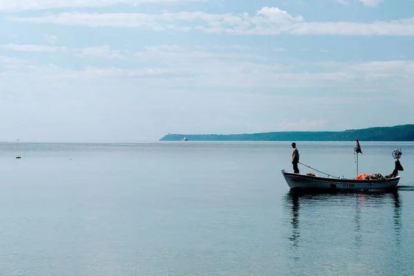 Balıkçı teknesinde duruyor.