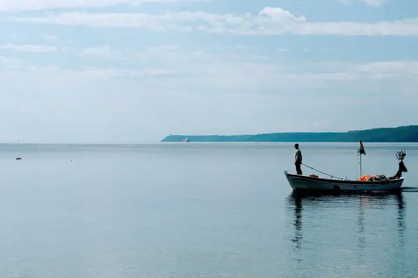 Teknede duran bir balıkçı.