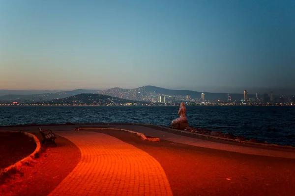 Sahilde gün batımlı bir kadının gözlem güvertesinden.