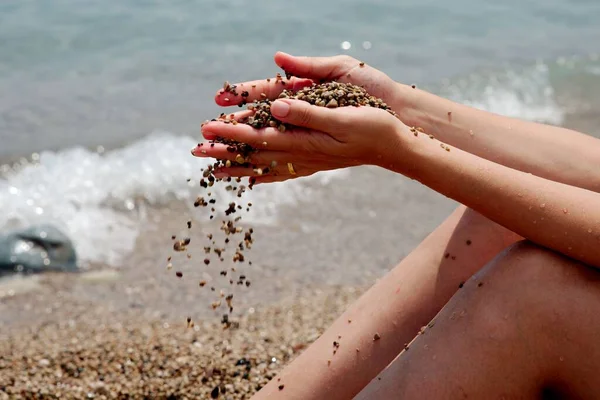 Denizde kumla kaplanmış kadın ellerine.