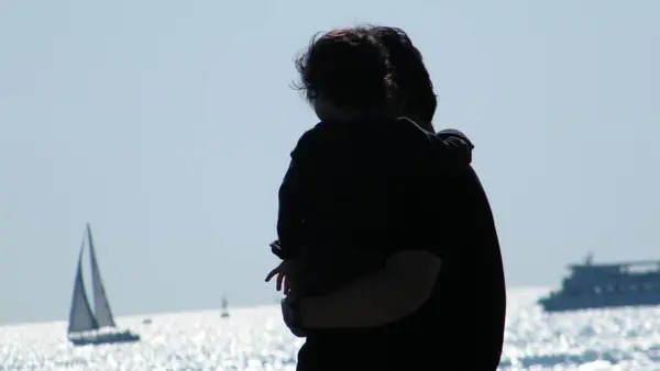 Baba ve oğul, denizcileri izliyorlar.