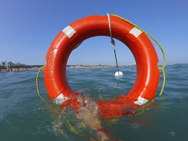 Kırmızı can simidi ve denizde bir şamandıra.