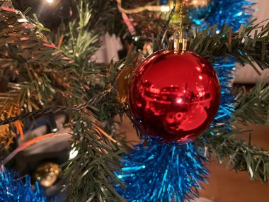 Bu görüntüdeki Noel 'in ihtişamına bakın. Renkli süslerle süslenmiş güzel bir ağaç, parıldayan ışıklar ve tepesinde bir yıldız. Sıcak, şenlikli bir atmosfer ve hediyelerle çevrelenmiş, tatil sezonunun özünü yakalıyor.