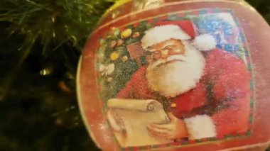 Büyük salonda kırmızı ve altın çiçeklerle süslenmiş Noel ağacı, toplar, ışıklar ve çelenkler. 
