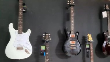 Müzik dükkanında bir sürü modern renkli elektro gitar ve bas gitar var. Yüksek kalite 4k görüntü