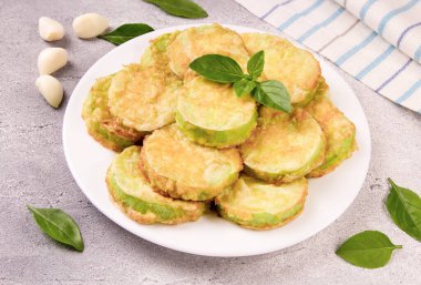 Peynirli fırında kabak, sarımsak ve gri arka planda taze otlar. Lezzetli yemek..