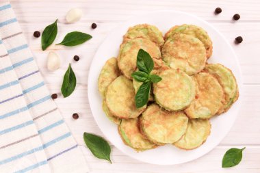 Beyaz ahşap arka planda peynirli, sarımsaklı ve taze otlu fırında kabak. Lezzetli yemek..