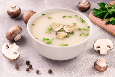 Gri arka planda bir kasede ev yapımı mantar çorbası. Lezzetli yemek..