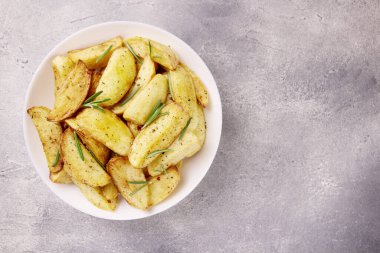 Kızarmış patates. Gri bir taşın üzerinde baharatlarla pişirilmiş patates dilimleri.. 