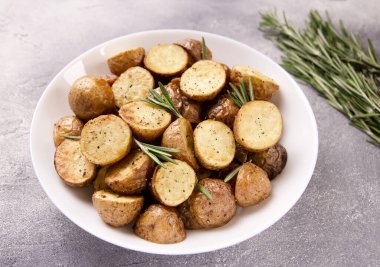 Baharatlı fırında patates ve gri arka planda biberiye.
