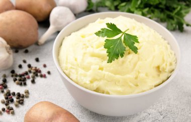Geleneksel ev yapımı, gri beton arka planda beyaz kasede patates püresi. Sağlıklı yemek.