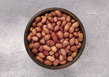 Gri masadaki bir kasede organik çiğ fıstık. Doğal besin organik gıda..