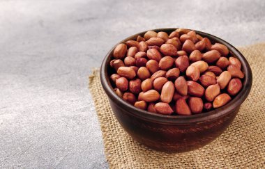 Gri masadaki bir kasede organik çiğ fıstık. Doğal besin organik gıda..