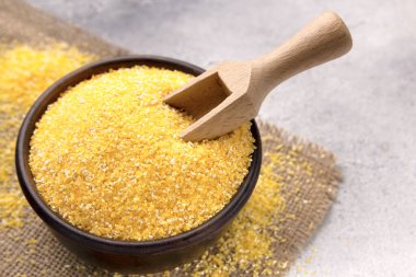 Gri bir masada kasede çiğ mısır unu, yakın plan. Metin için boşluk