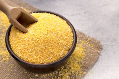 Gri bir masada kasede çiğ mısır unu, yakın plan. Metin için boşluk