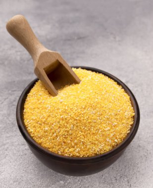 Gri bir masada kasede çiğ mısır unu, yakın plan. Metin için boşluk