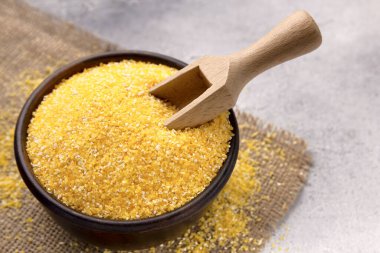 Gri bir masada kasede çiğ mısır unu, yakın plan. Metin için boşluk