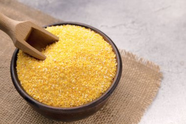 Gri bir masada kasede çiğ mısır unu, yakın plan. Metin için boşluk