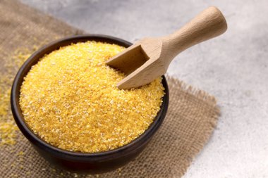 Gri bir masada kasede çiğ mısır unu, yakın plan. Metin için boşluk