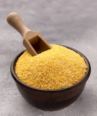 Gri bir masada kasede çiğ mısır unu, yakın plan. Metin için boşluk