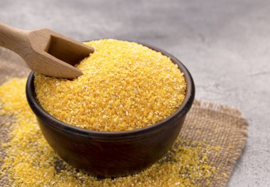 Gri bir masada kasede çiğ mısır unu, yakın plan. Metin için boşluk