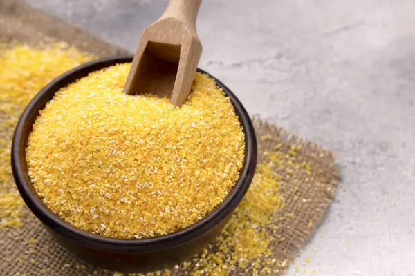 Gri bir masada kasede çiğ mısır unu, yakın plan. Metin için boşluk