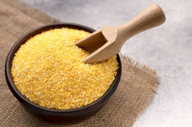 Gri bir masada kasede çiğ mısır unu, yakın plan. Metin için boşluk