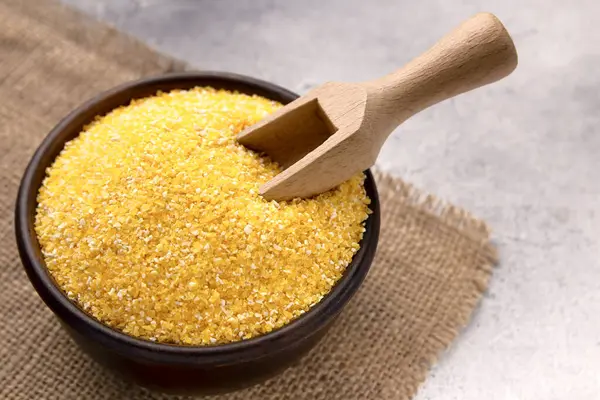 Gri bir masada kasede çiğ mısır unu, yakın plan. Metin için boşluk