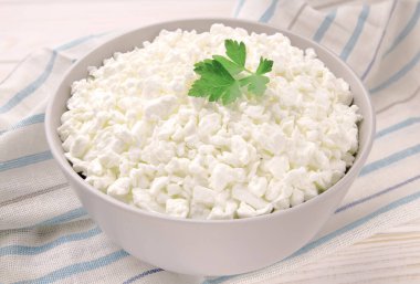 Hafif ahşap arka planda bir kasede çiftlik peyniri. Maydanozlu süzme peynir. Kasedeki süzme peynir..