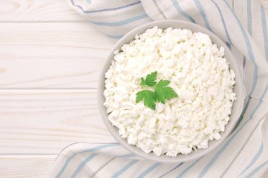 Hafif ahşap arka planda bir kasede çiftlik peyniri. Maydanozlu süzme peynir. Kasedeki süzme peynir..