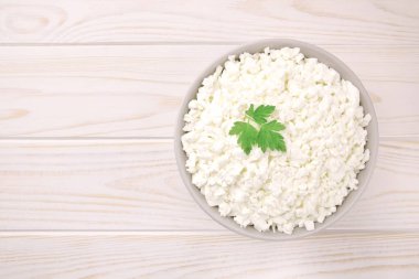 Hafif ahşap arka planda bir kasede çiftlik peyniri. Maydanozlu süzme peynir. Kasedeki süzme peynir..