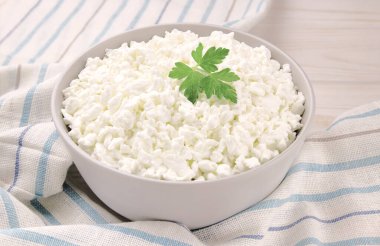 Hafif ahşap arka planda bir kasede çiftlik peyniri. Maydanozlu süzme peynir. Kasedeki süzme peynir..