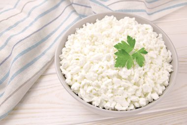 Hafif ahşap arka planda bir kasede çiftlik peyniri. Maydanozlu süzme peynir. Kasedeki süzme peynir..