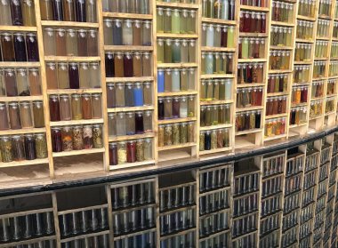 Amsterdam 'da organik maddeyle dolu renkli şişelerden oluşan açık renkli bir duvar.