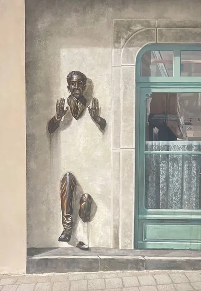 フランスのドールの店の隣の壁を歩いている男の壁画です — ストック写真