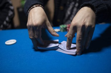 Texas Hold em poker oynamak için kartları karıştıran dağıtıcı