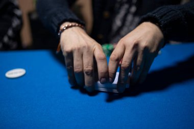 Texas Hold em poker oynamak için kartları karıştıran dağıtıcı