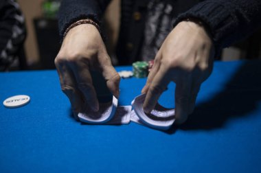 Texas Hold em poker oynamak için kartları karıştıran dağıtıcı
