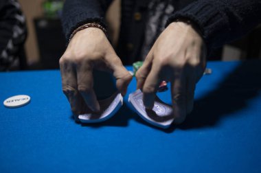 Texas Hold em poker oynamak için kartları karıştıran dağıtıcı