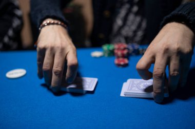 Texas Hold em poker oynamak için kartları karıştıran dağıtıcı