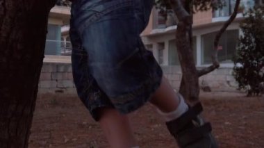 Parkta yeni yürümeye başlayan çocuk. Ayaklarını kapayarak şaşkın yüz ifadesini gösteriyor. Ağır çekim. Yüksek kaliteli FullHD görüntüler