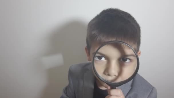 Neugieriges Knabenkind Anzug Mit Lupe Über Den Augen Hochwertiges Fullhd — Stockvideo