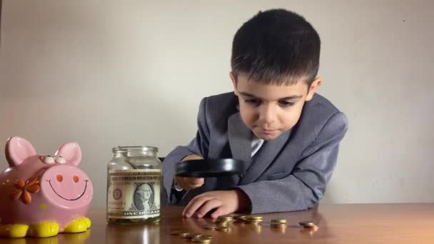 Invertir Temprana Edad Niño Con Traje Investigando Dinero Con Lupa — Vídeos de Stock