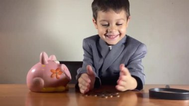 Küstah açgözlü çocuk, takım elbiseli çocuk kumbaradaki paraları sayıyor. Yatırım konsepti ve çocuk tasarrufu. Yüksek kalite 4k görüntü